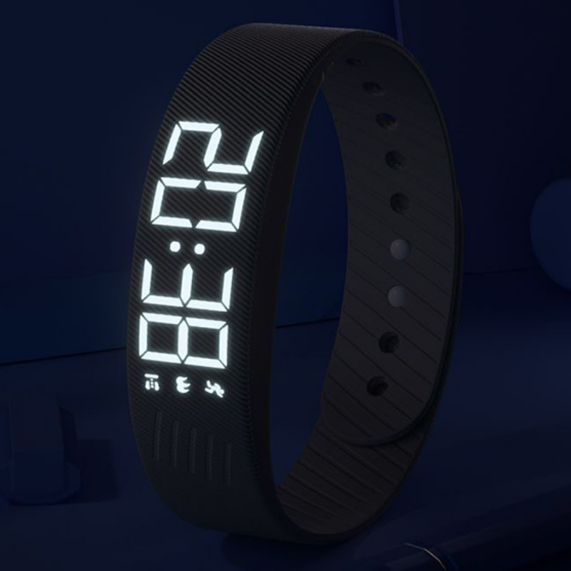 The LUNDIVA band in a dark bedroom with its LED time display lit